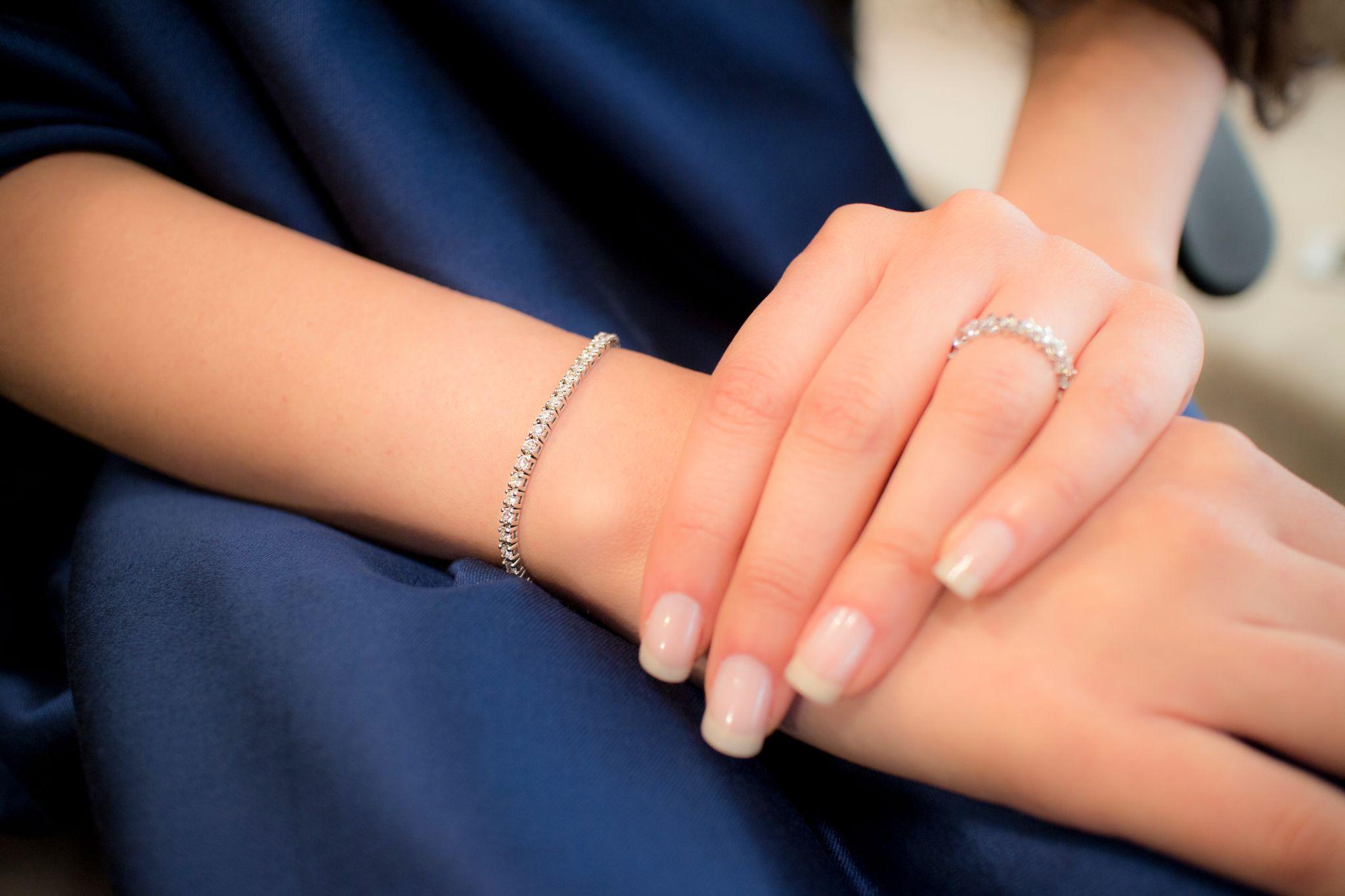 close-up of woman's hands wearing diamond bracelet and ring