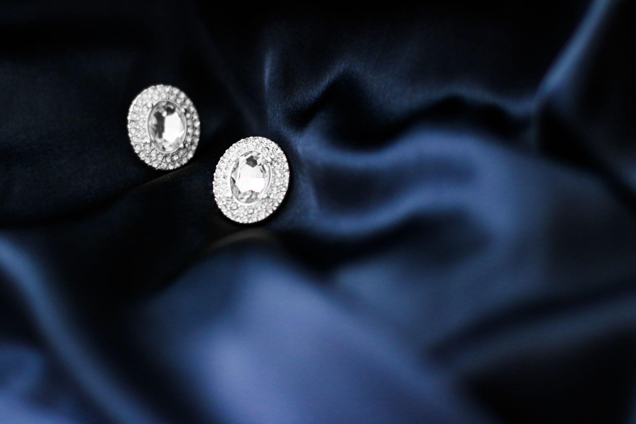 two diamond earrings on blue silk