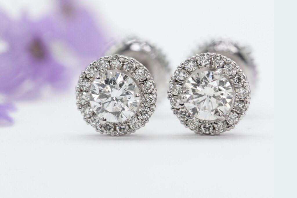 Pair of diamond earrings on a white table.
